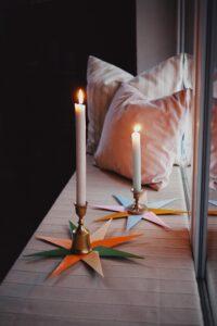 Papiersterne mit Kerzenständer auf Fensterbank